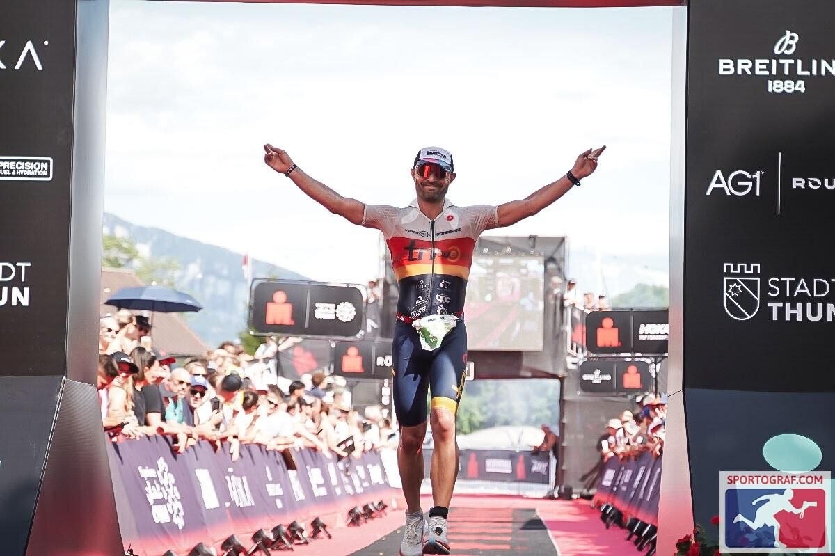 Jean-Brice Combebias sur la finish line de l'IRONMAN Switzerland Thun 2026, bras levés.
