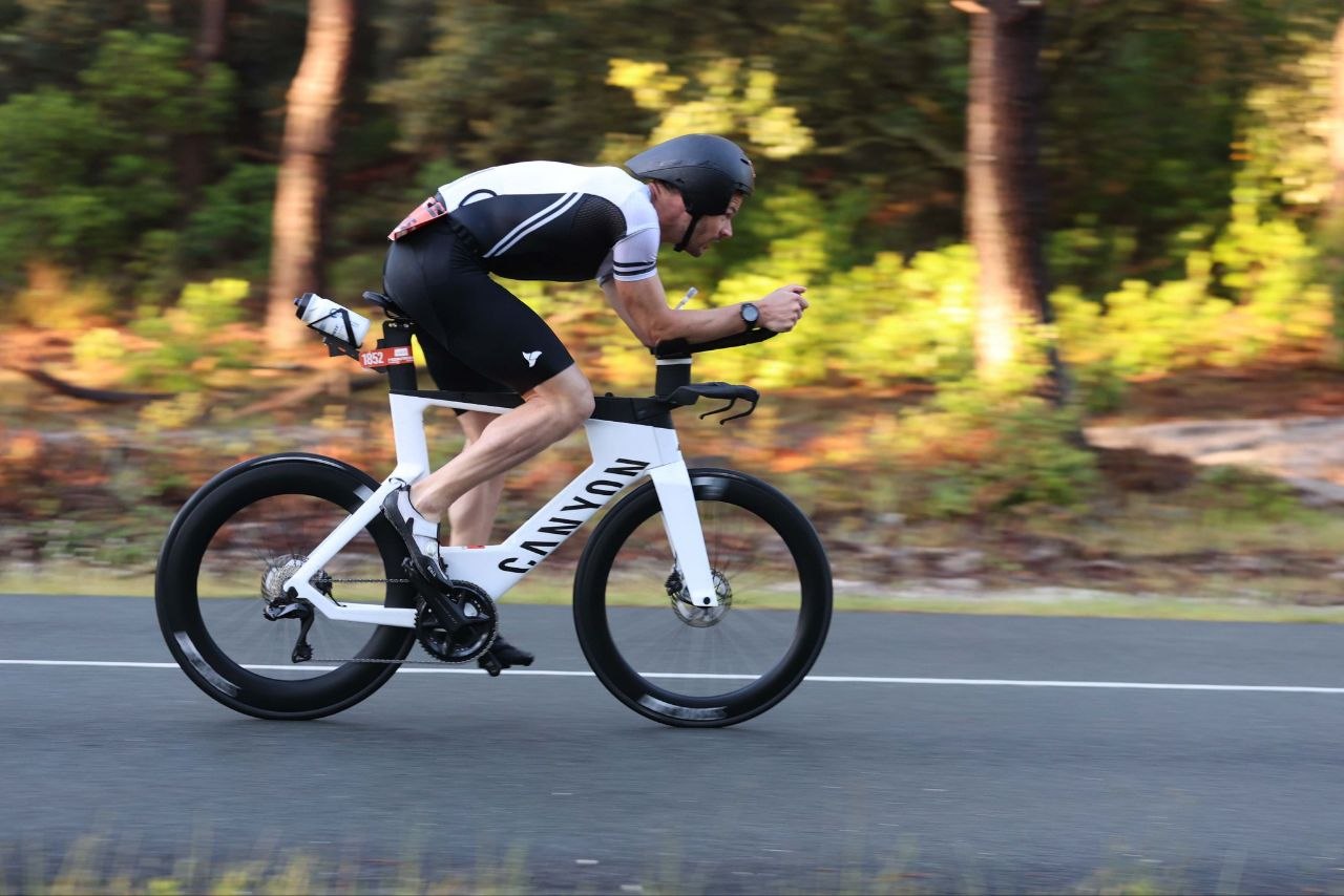 Triathlète en tenue BPC rouge noire et blanche sur une course longue distance
