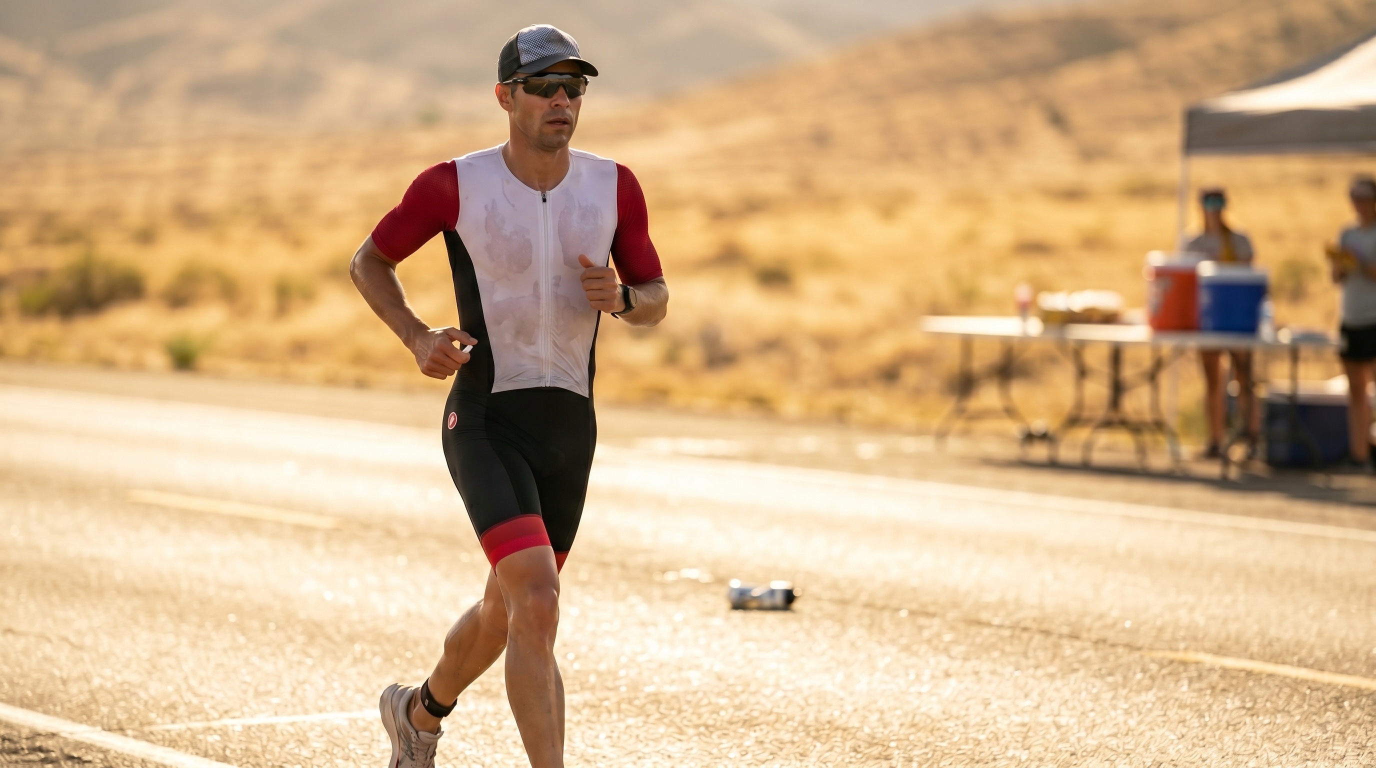 Triathlète en tenue BPC pendant une sortie chaude, avec une capsule de sel visible dans la main