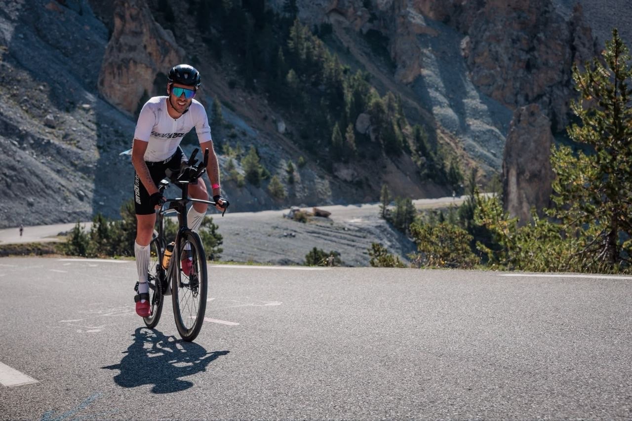 Thomas Sayer à vélo sur une route de haute montagne lors de sa préparation longue distance.